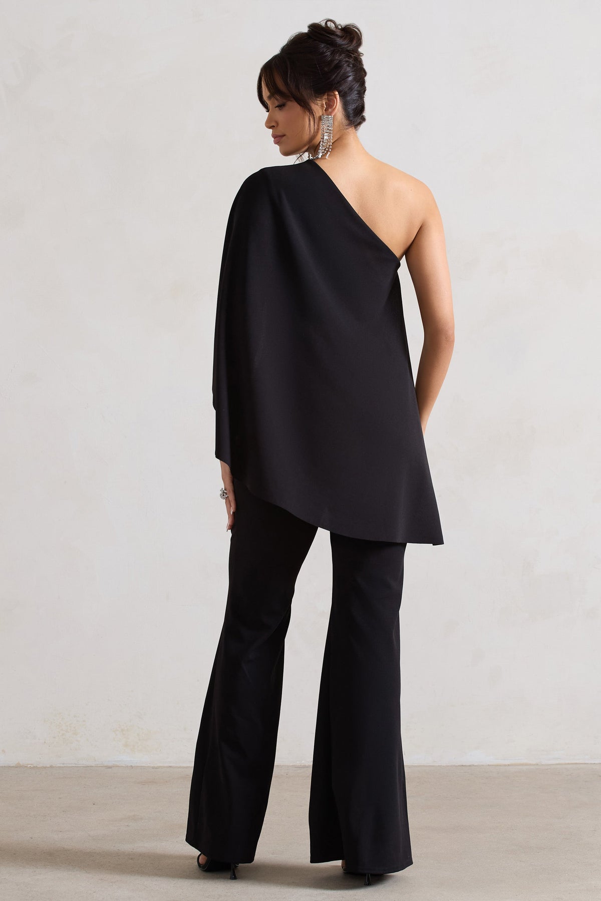 Pristine | Schwarzer Ein-Schulter-Jumpsuit mit Umhangärmel und ausgestelltem Bein