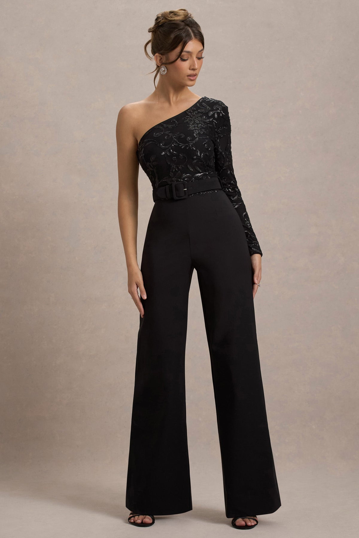 Upgrade | Schwarzer Spitzen-Jumpsuit mit asymmetrischem Schnitt und Gürtel sowie weitem Beinabschluss.