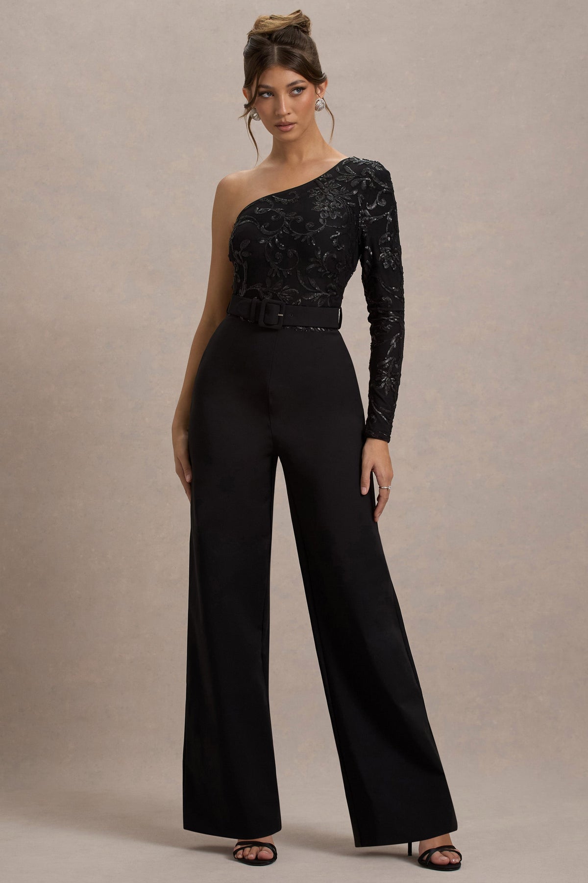 Upgrade | Schwarzer Spitzen-Jumpsuit mit asymmetrischem Schnitt und Gürtel sowie weitem Beinabschluss.