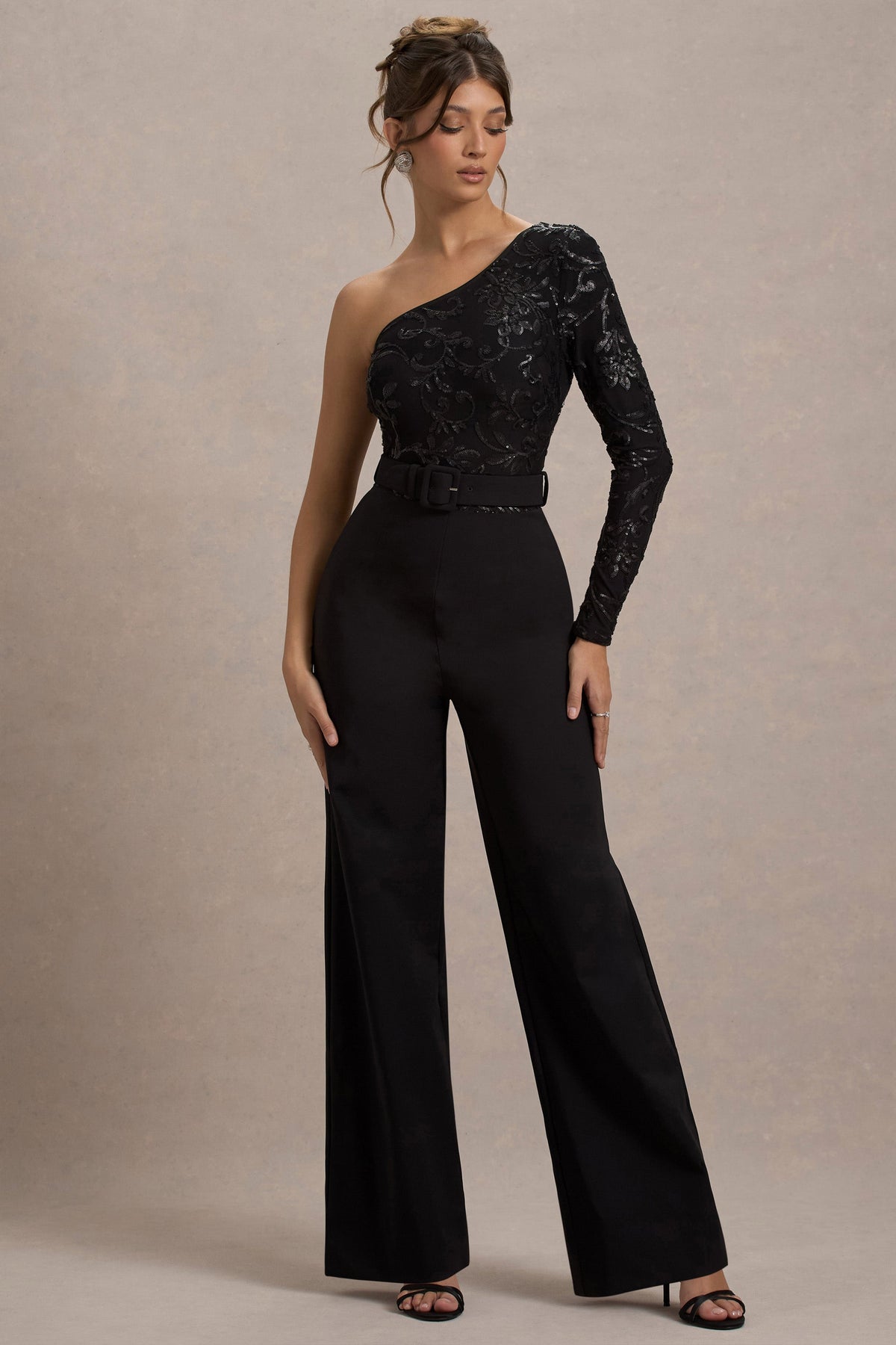 Upgrade | Schwarzer Spitzen-Jumpsuit mit asymmetrischem Schnitt und Gürtel sowie weitem Beinabschluss.