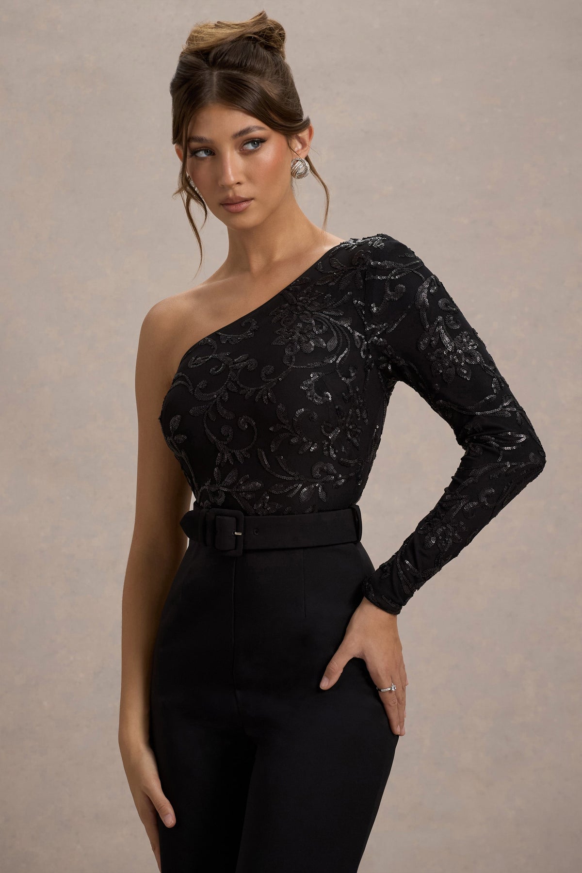 Upgrade | Schwarzer Spitzen-Jumpsuit mit asymmetrischem Schnitt und Gürtel sowie weitem Beinabschluss.