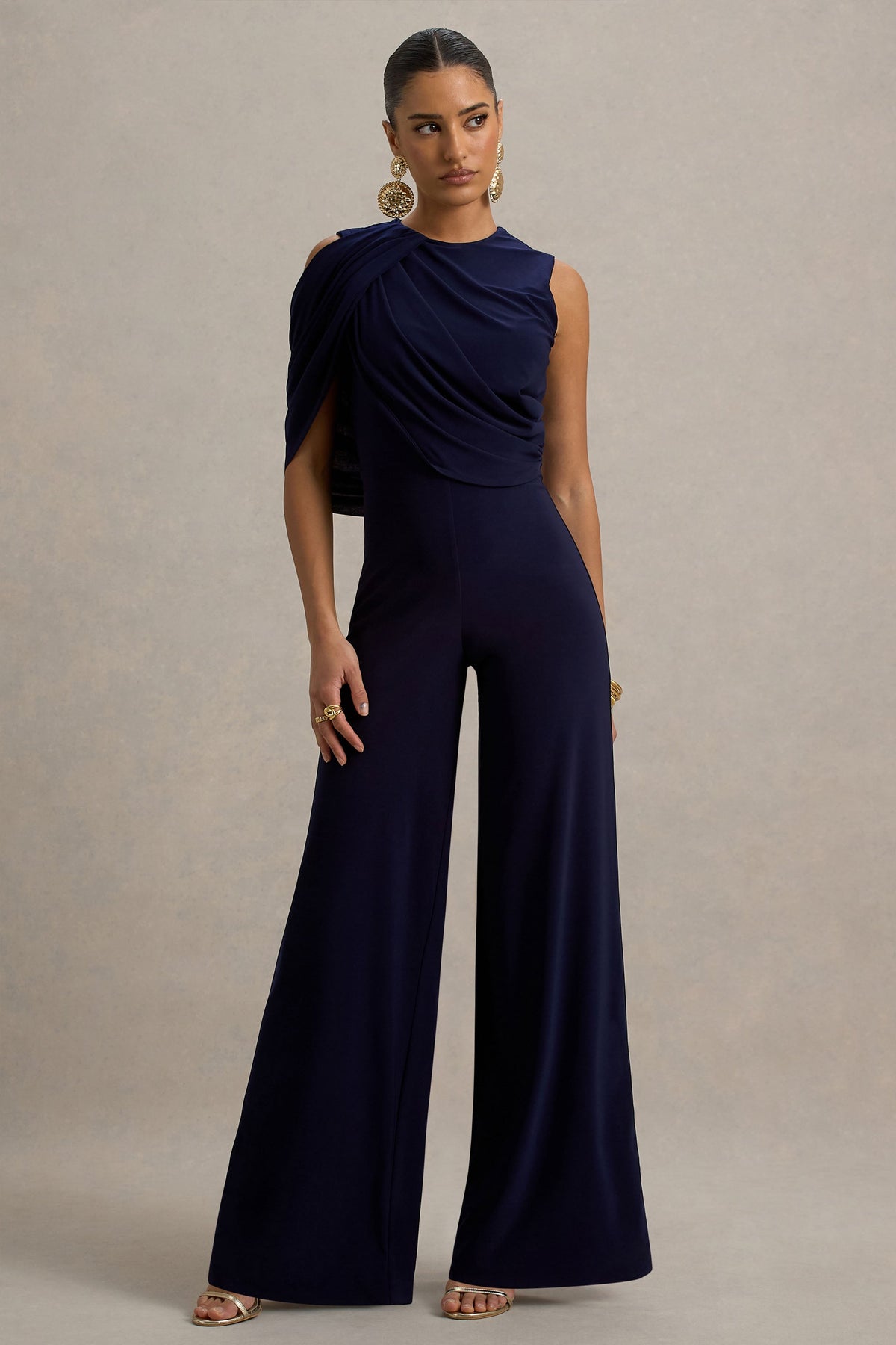 Opulence | Marineblauer Jumpsuit mit Cape-Ärmeln und drapierten Details.