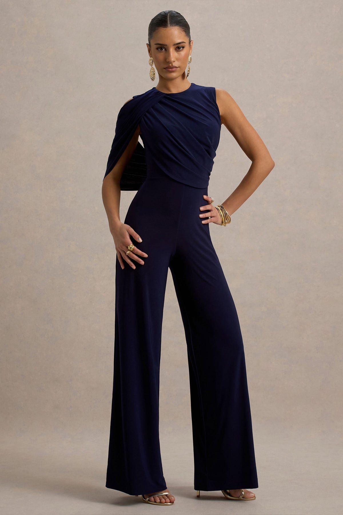 Opulence | Marineblauer Jumpsuit mit Cape-Ärmeln und drapierten Details.